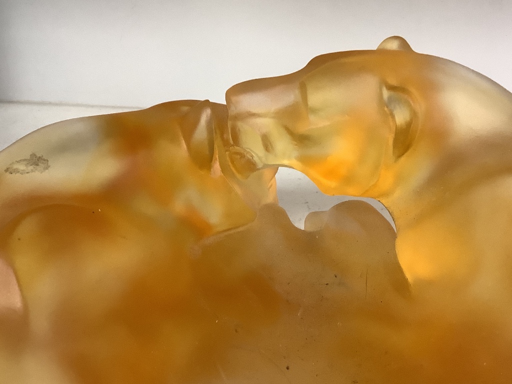 An amber glass dish with a recumbent lioness, signed, 24cm wide, apocryphal Daum mark